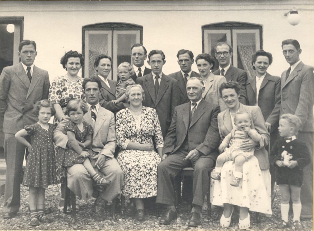 Peder og Frida med børn, svigerbørn og de første børnebørn. Billedet er fra omkring 1954. Bagest fra venstre: Bent, Anne (Frederiks kone), Anna, Anette, Søren (Annas mand), Hakon, Leo, Erna (Leos kone), Henning (min far), Helga, Vagn (Helgas mand). Forrest fra venstre: Anne Grethe og Norma (Anne og Frederiks to første piger), Frederik, Frida, Peder, Erna (min mor), Per (min bror), Jørn (Helga og Vagns søn)